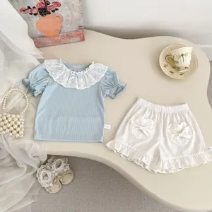 Detail of baby girl summer outfit with lace collar top and heart pocket shorts