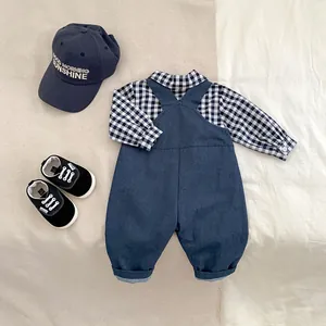 Flat lay of baby boy navy overalls set with checkered shirt and embroidered cap