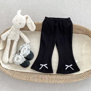 Détails du pantalon évasé noir pour fille avec nœuds blancs et coutures élégantes