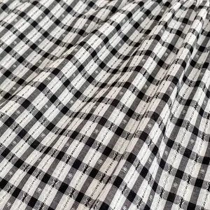 Close-up of black and white gingham fabric with detailed seersucker texture and soft folds