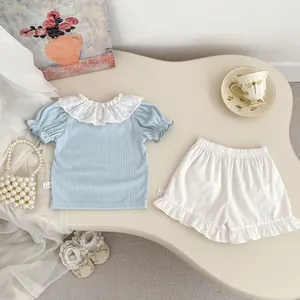 Detail of baby girl summer outfit featuring lace collar and ribbed knit texture