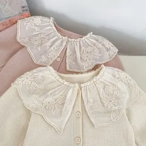Detailansicht der floralen Spitzenkragen auf Waffelstrickjacken in Beige und Rosa