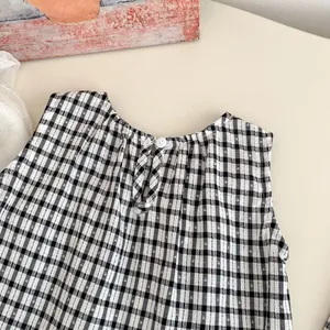 Detail of baby girl gingham top showing back keyhole closure with a white button