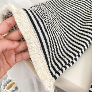Dettaglio macro del tessuto a maglia a righe bianche e nere con bordo a frange