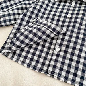 Close-up of black and white gingham shirt featuring cotton linen texture and white buttons