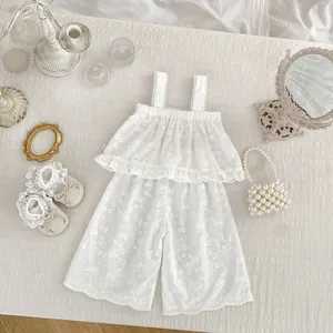 Détail de l'ensemble filles avec débardeur brodé et pantalon large blanc crème