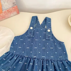 Detailed macro view of denim girl's dress featuring white bow and heart patterns
