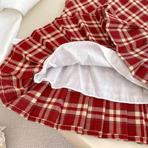 Abito a pieghe scozzese rosso da bambina con fodera bianca e cuciture di alta qualità