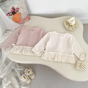 Dettaglio di top in maglia per neonata con bordo in pizzo delicato e balze eleganti