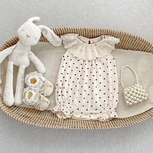 Détail du barboteuse bébé été avec motif cœur et col volanté en dentelle blanche délicate