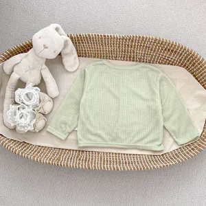 Detail der hellgrünen Baby-Strickjacke aus Rippbaumwolle mit atmungsaktivem Stoff