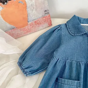 Detail view of denim baby romper with Peter Pan collar and elastic ruffled sleeve cuffs