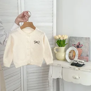 Detailansicht der Strickjacke für Mädchen mit Rautenmuster und schwarzer Schleife