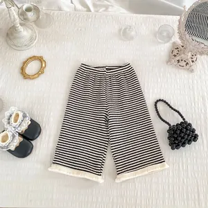 Pantaloni a gamba larga a righe bianche e nere per bambini con orlo a frange ed elastico