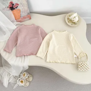 Detailansicht von rosa und beige Baby-Waffelstrick-Shirts mit Rüschensaum-Verzierung