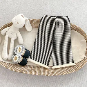 Dettaglio dei pantaloni in maglia a righe per neonati con frange sul bordo