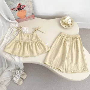 Detail von beige Mädchen-Sommerset mit Leinentextur, Holzknöpfen und Schleifenträgern