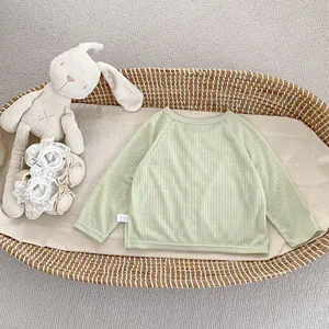 Détail du vêtement de protection solaire vert sauge pour bébé en maille côtelée douce