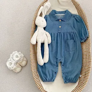 Detail of baby denim romper with Peter Pan collar and wooden buttons in a woven basket