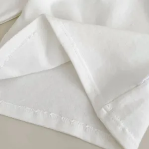Dettaglio ravvicinato della doppia cucitura sull'orlo di un vestito in cotone bianco