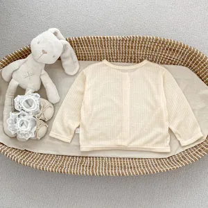 Detail der Baby-Sonnenschutz-Strickjacke mit Rippstruktur in einem Weidenkorb