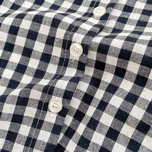 Macro shot of plaid shirt fabric detail with neat white buttons and gingham pattern