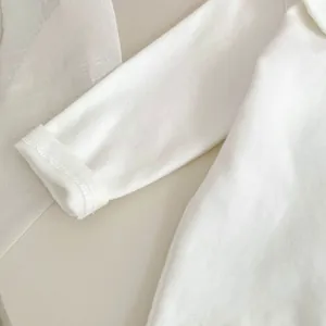 Dettaglio dei polsini in cotone lavorato a maglia bianca con cuciture di alta qualità