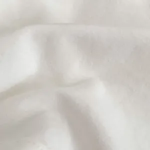 Primo piano del tessuto in cotone bianco morbido con dettagli ricamati sull'abito da bambina