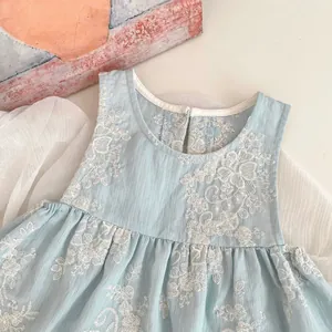 Detailansicht hellblaues Babykleid mit weißer Blumenstickerei und Baumwollstruktur