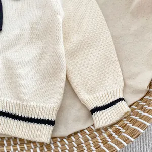 Detailed close-up of ribbed knit cuffs and hem with minimalist black stripe accent