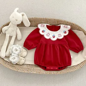 Dettaglio body neonato rosso con colletto a onde e ricami di coniglietto e fragole dolci