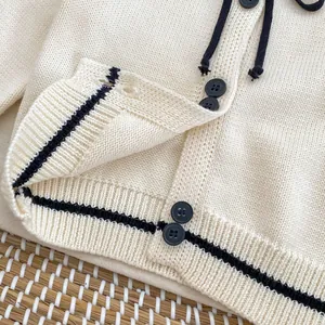 Girls cream knit cardigan with black contrast stripes and bow tie detail