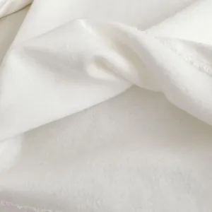 Dettaglio della trama in maglia bianca e delle cuciture precise della maglia da bambina
