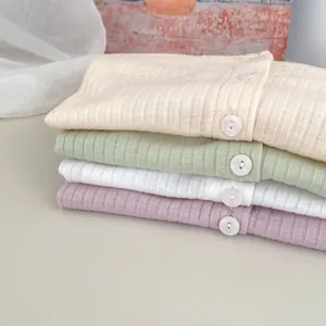Detailansicht der Rippstrick-Textur und Knöpfe an bunten Baby-Strickjacken für den Sonnenschutz
