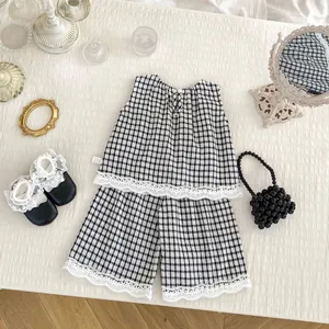Detailed view of the gingham fabric and delicate lace trim on the girl's summer outfit