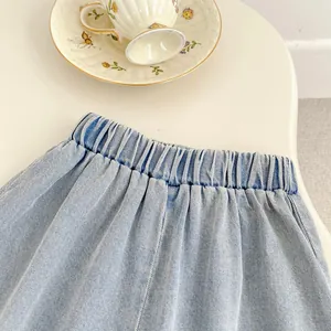 Detail of light blue denim pants with an elastic waist and fine twill texture fabric