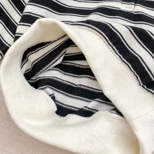 Detailed close-up of black and white striped knit fabric and premium ribbed hem finish