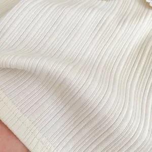 Close-up of white ribbed knit fabric for baby girl lace collar long sleeve shirt