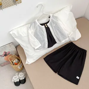 Flachbild-Detail des Mädchen-Sommersets mit weißem Cardigan und schwarzer Shorts