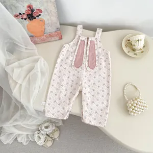Flachbild von Baby-Strampler mit Blumenmuster, rosa Hasenohren und Spitzen-Söckchen