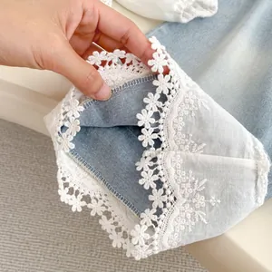 Girls' blue jeans with delicate white lace hem embroidery and floral hollow detail