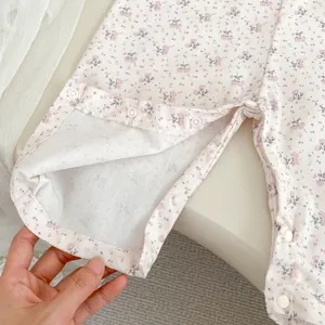 Detailansicht des geblümten Babybodys mit praktischen weißen Druckknöpfen im Schrittbereich