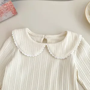 Detail of baby girl cream ribbed shirt with delicate lace Peter Pan collar and button back