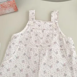 Detail von Baby-Latzhose mit Blumenmuster aus Cord, mit Tasche und Knopfriemen