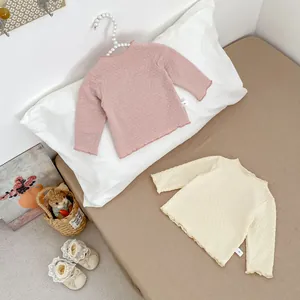 Detail von Baby-Langarmshirts mit feinen Rüschenkanten und strukturierter Jacquard-Optik