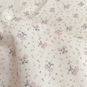 Nahaufnahme von Baumwoll-Twill mit Blumenmuster und einem weißen Druckknopf-Detail