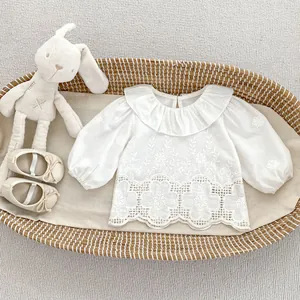 Detail of white cotton shirt featuring ruffled collar and floral embroidery for girls