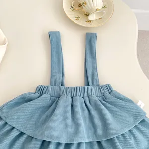 Detailed view of baby blue corduroy suspender dress with ruffle trim and 66 size tag