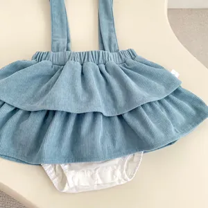 Close-up of Morandi blue corduroy baby romper with ruffle skirt and snap buttons