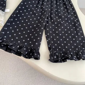 Close-up of floral print trousers with ruffled hems and size 73 label for girls